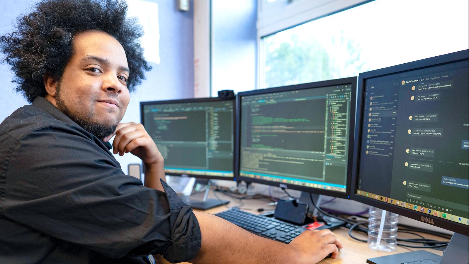 Software developer with multiple computer screens